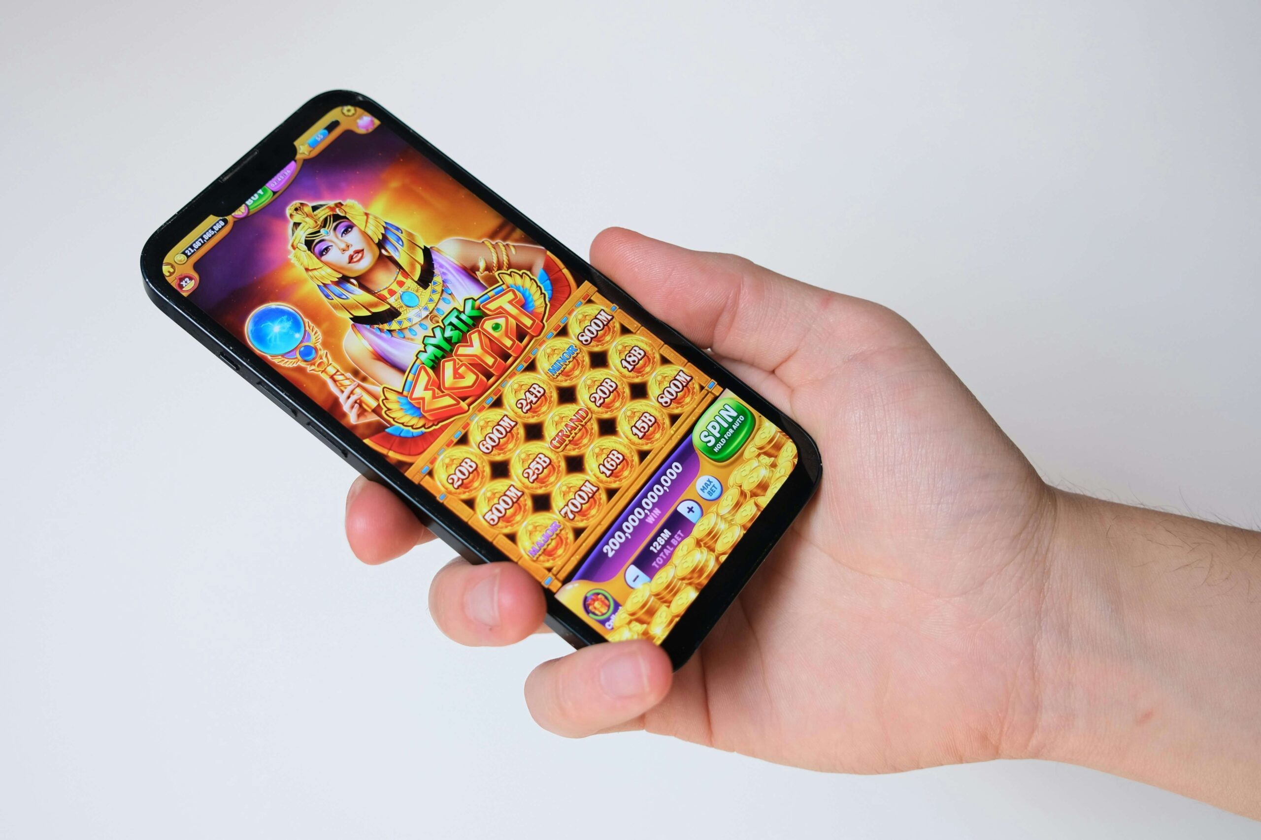 Hand holding a mobile phone with a playable game ad (rich media advertising).